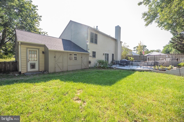 rear view of property with a yard and a patio area