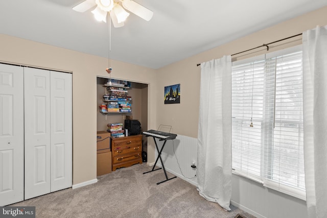 home office with plenty of natural light, light carpet, and ceiling fan