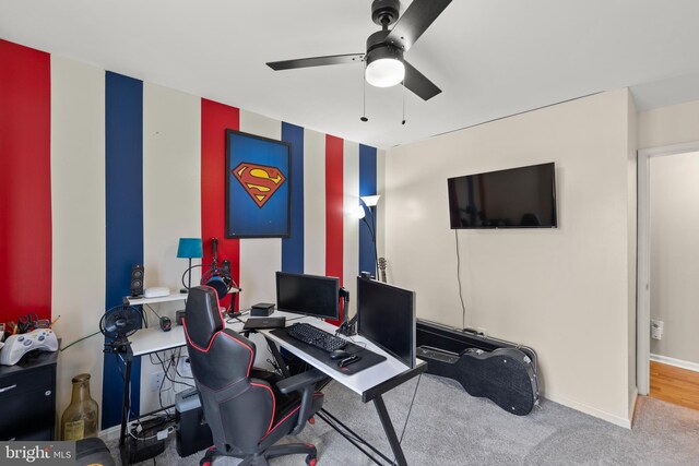 carpeted home office featuring ceiling fan