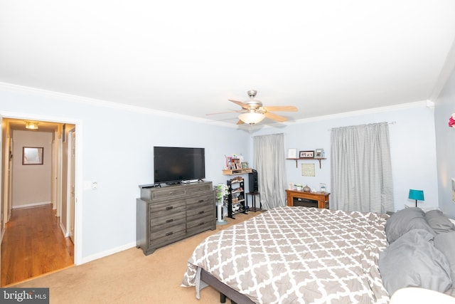 carpeted bedroom featuring crown molding and ceiling fan