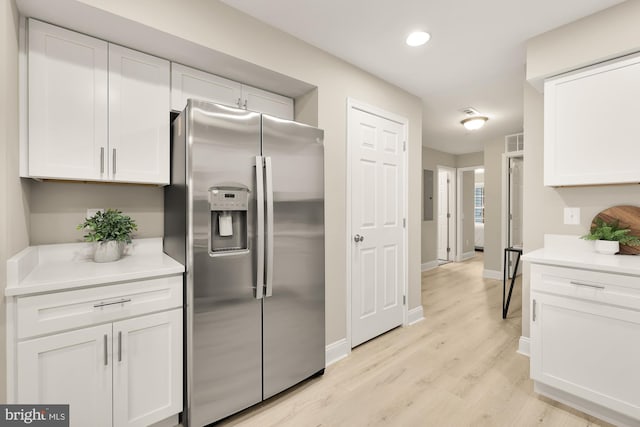 kitchen featuring white cabinetry, stainless steel refrigerator with ice dispenser, and light countertops