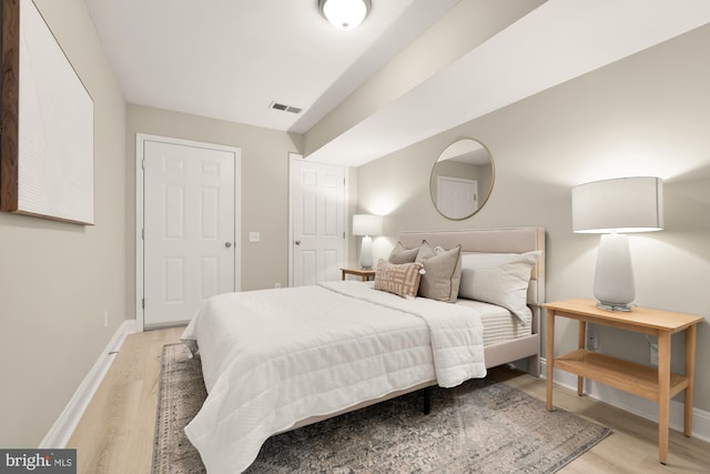 bedroom featuring light wood-type flooring, visible vents, and baseboards