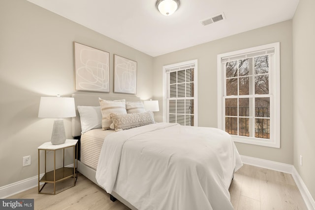 bedroom featuring light wood-style floors, baseboards, and visible vents