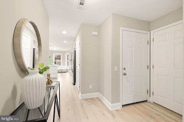 hall featuring baseboards, recessed lighting, visible vents, and light wood-style floors