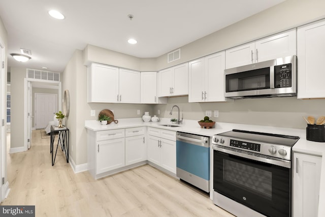 kitchen with stainless steel appliances, light countertops, visible vents, and white cabinetry