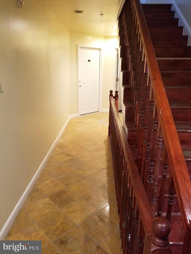 hall featuring stairs and baseboards