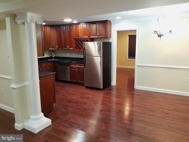 kitchen featuring decorative columns, baseboards, dark wood finished floors, dark countertops, and stainless steel appliances