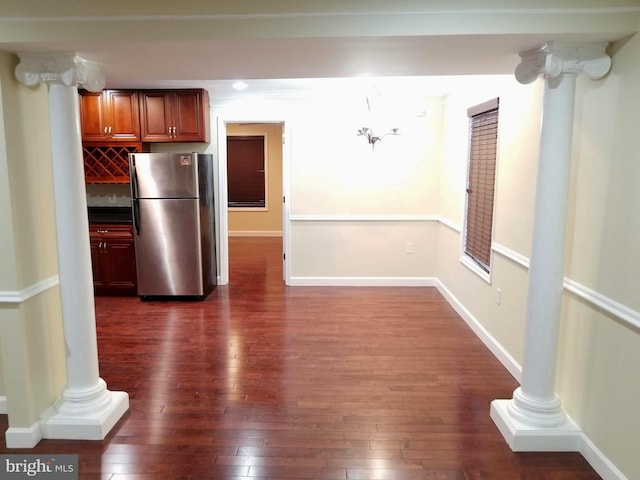 kitchen with decorative columns, baseboards, dark wood finished floors, and freestanding refrigerator