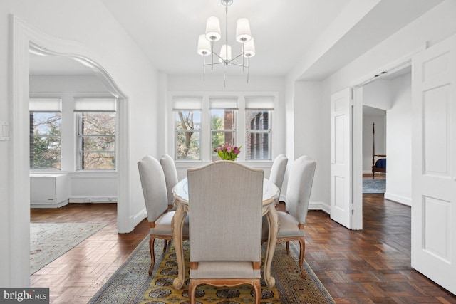 dining area with baseboards, a chandelier, and a wealth of natural light