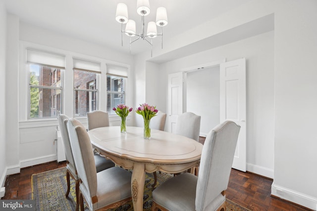 dining space featuring baseboards and a notable chandelier