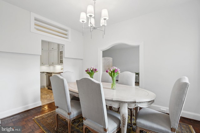 dining area featuring baseboards and an inviting chandelier