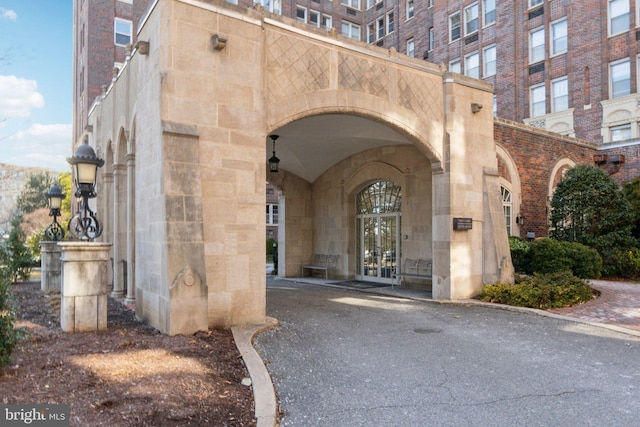 entrance to property with stone siding, french doors, and brick siding