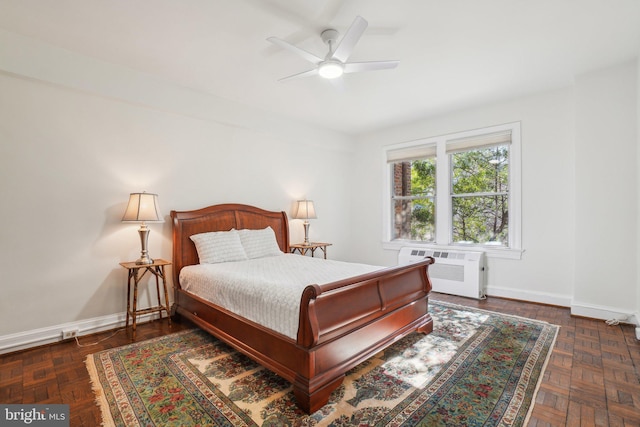 bedroom featuring a wall unit AC, baseboards, and a ceiling fan