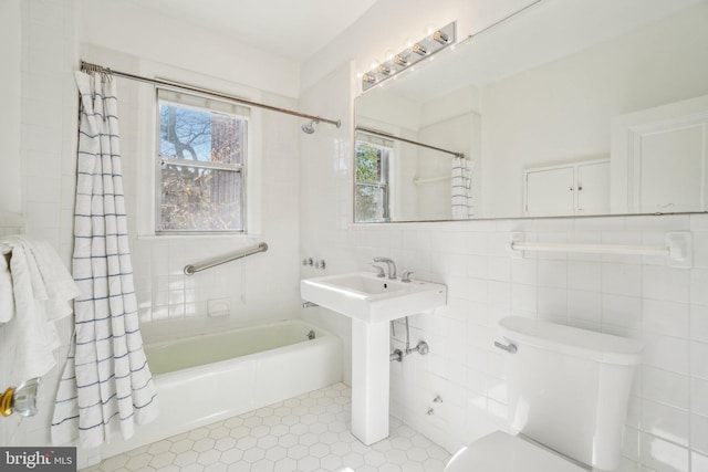 full bath featuring shower / tub combo, tile walls, and toilet