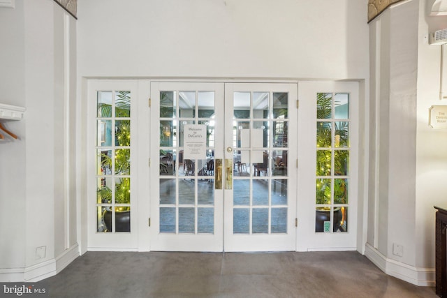 doorway to outside featuring french doors, concrete floors, and baseboards