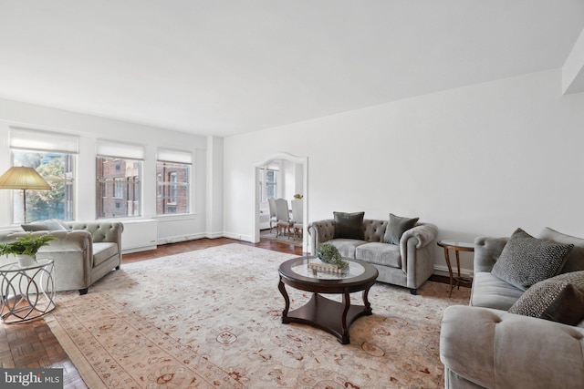 living room featuring arched walkways and baseboards