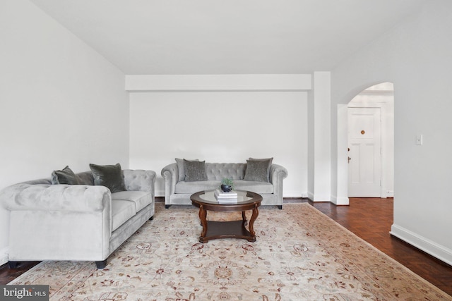 living room featuring arched walkways and baseboards