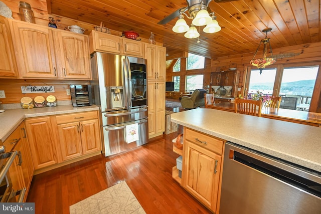 kitchen with wood walls, decorative light fixtures, wooden ceiling, appliances with stainless steel finishes, and dark hardwood / wood-style floors