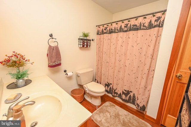 bathroom featuring walk in shower, wood-type flooring, toilet, and vanity