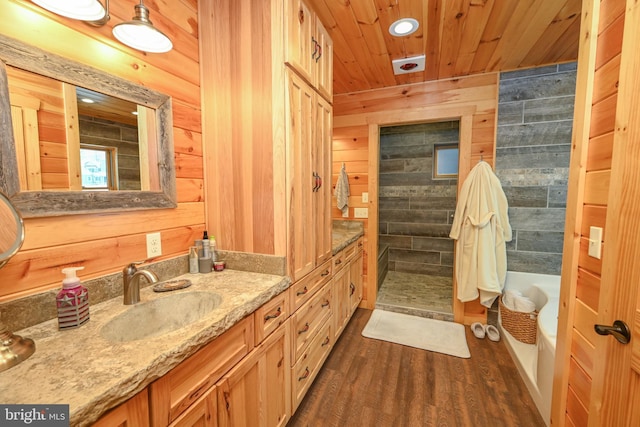 bathroom featuring hardwood / wood-style flooring, wooden walls, vanity, wooden ceiling, and shower with separate bathtub