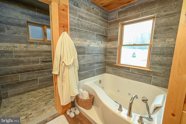 bathroom with wooden walls and a tub to relax in