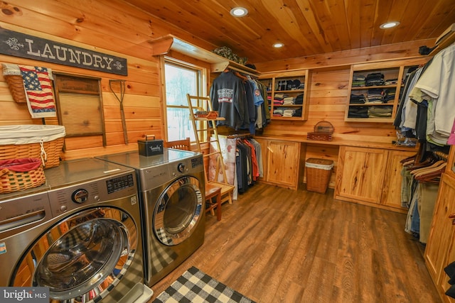 clothes washing area with wood ceiling, independent washer and dryer, dark hardwood / wood-style flooring, and wooden walls