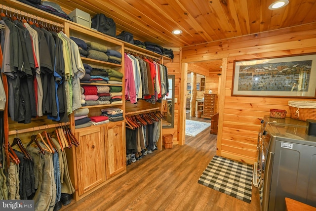 spacious closet with washing machine and clothes dryer and hardwood / wood-style floors