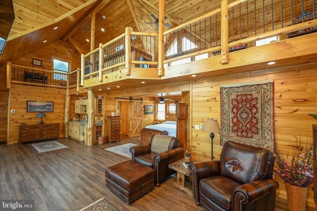 living room with wood-type flooring, a barn door, wood ceiling, and wood walls