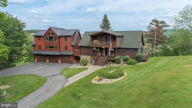 view of front of house with a garage, a front yard, a balcony, and a deck