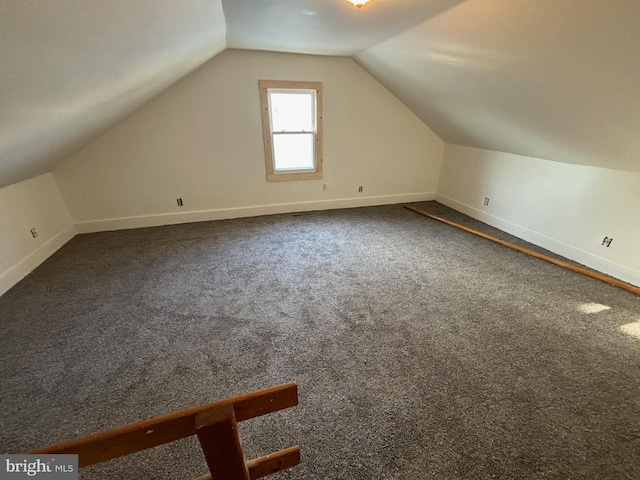 bonus room featuring dark colored carpet and vaulted ceiling