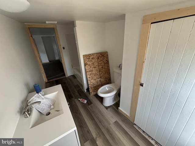 bathroom with hardwood / wood-style flooring and toilet