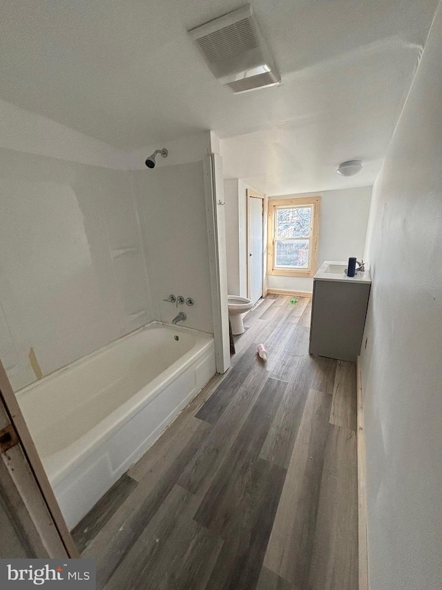 full bathroom with vanity, hardwood / wood-style floors, shower / bathtub combination, and toilet