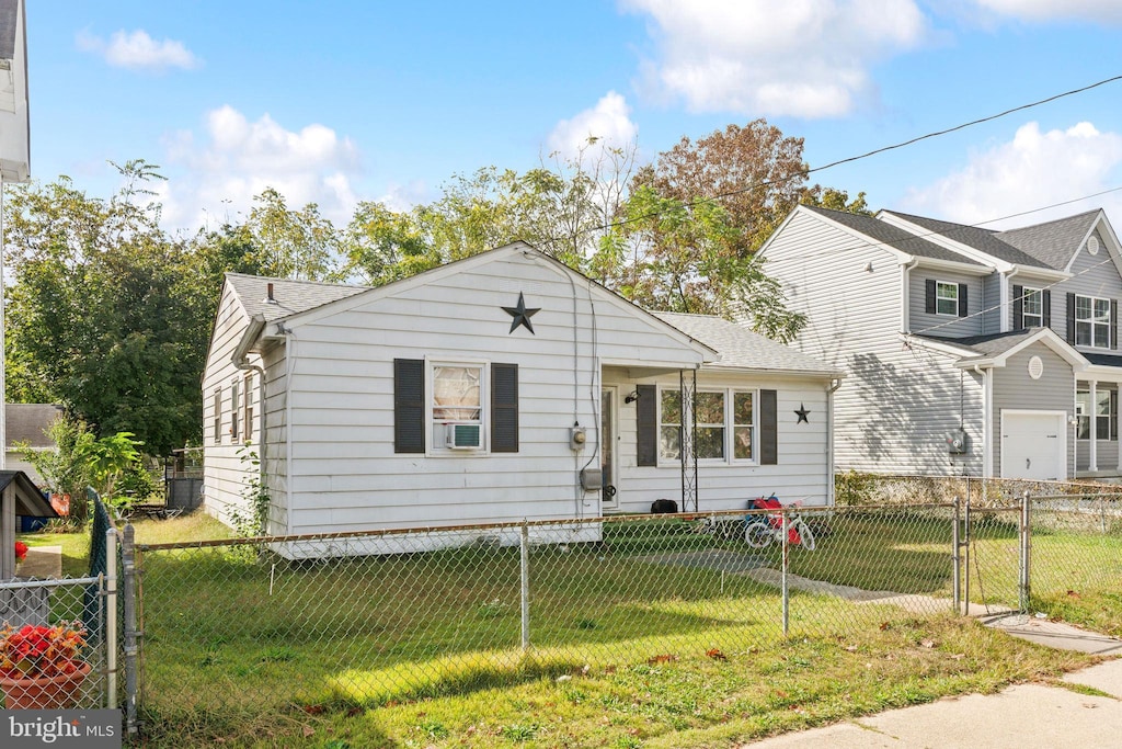 view of front facade with cooling unit and a front lawn