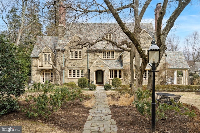 view of front of house featuring stone siding and a high end roof