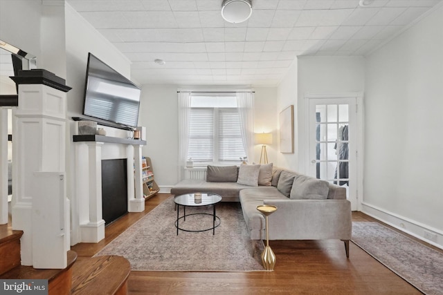 living room with wood-type flooring and ornamental molding