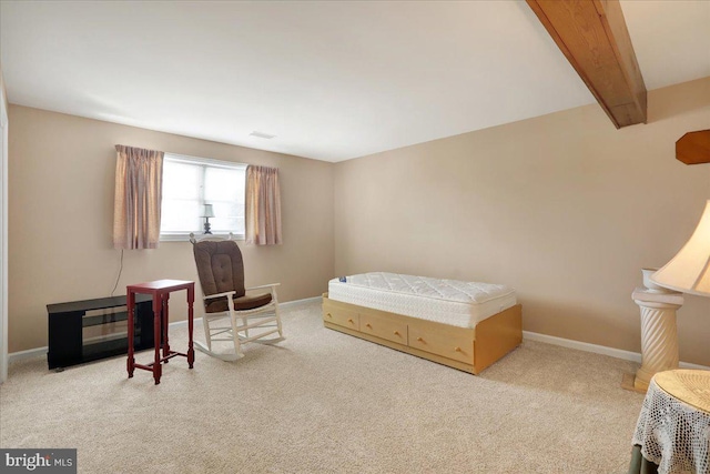 bedroom with beam ceiling and light colored carpet