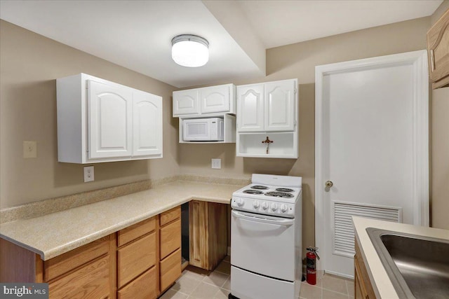 kitchen featuring sink, light tile patterned floors, white cabinets, and white appliances