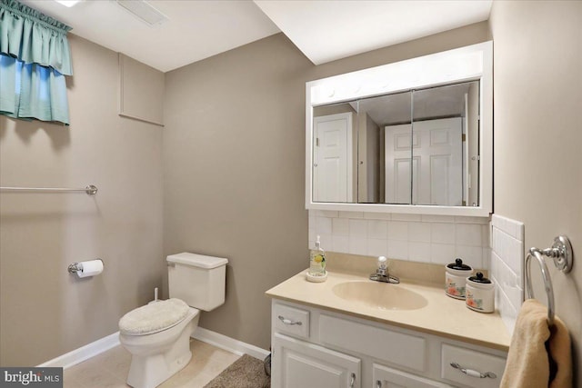 bathroom with vanity, backsplash, and toilet