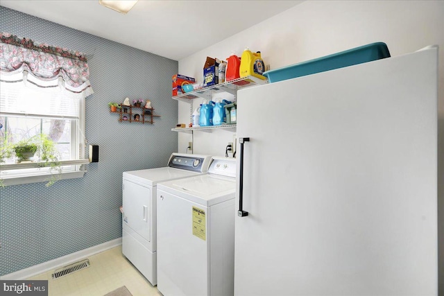 clothes washing area with washing machine and dryer