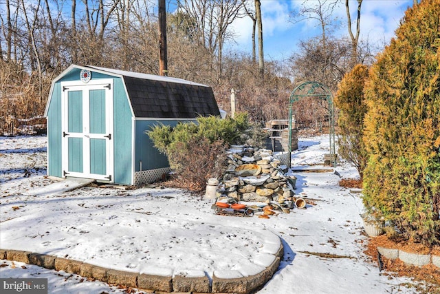 snowy yard featuring a shed