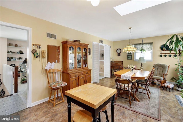 tiled dining room featuring a skylight