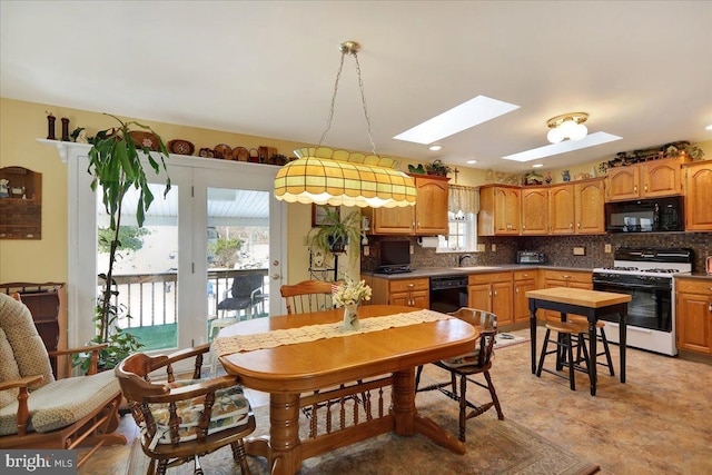 dining room with sink and a skylight