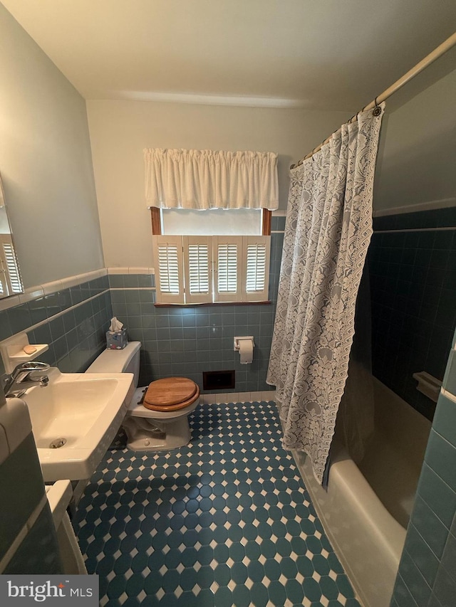 full bathroom featuring tile walls, sink, shower / bath combo, and toilet