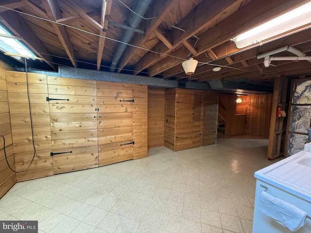 basement featuring wooden walls