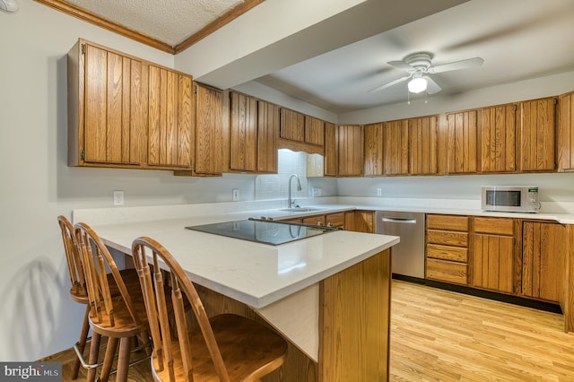 kitchen with stainless steel appliances, brown cabinets, and light countertops