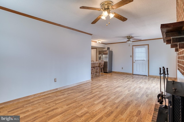 unfurnished living room featuring ornamental molding, baseboards, a ceiling fan, and wood finished floors