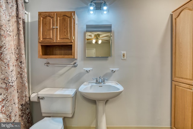 full bathroom featuring toilet, a shower with curtain, and ceiling fan