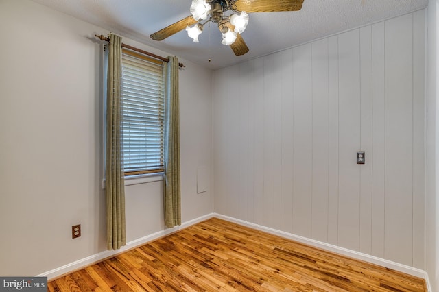 unfurnished room featuring ceiling fan, baseboards, and wood finished floors