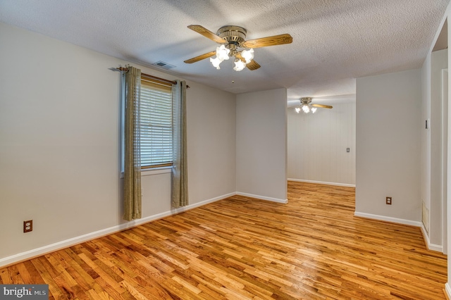 unfurnished room featuring visible vents, ceiling fan, and light wood-type flooring