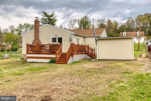 rear view of property with roof with shingles, a yard, a deck, and a chimney